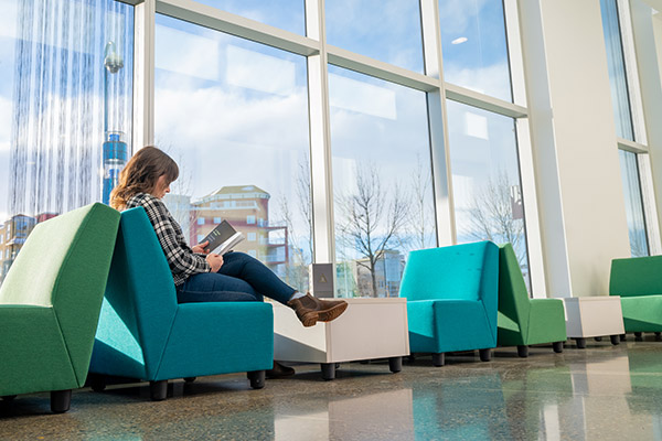 a female student sitting while reading a book