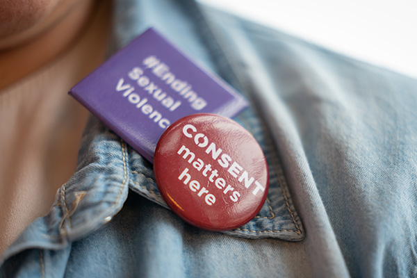 close up of two pins on the collar of a jean jacket