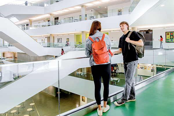a male and female student speaking in Allard Hall