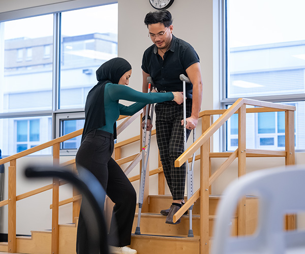 female student helping male down stairs