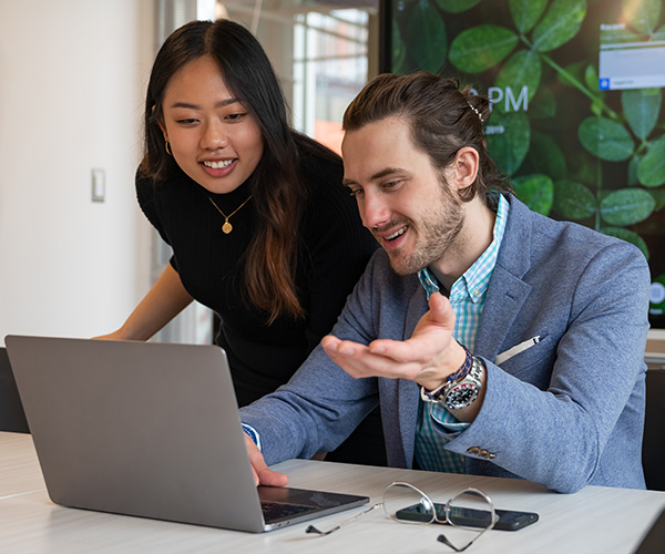 male and female student looking at laptop